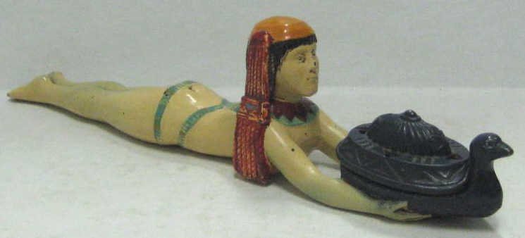ART DECO COLD-PAINTED METAL FIGURAL INCENSE BURNER: Egyptian Revival, Ronson design depicting Cleopatra lying with arms extended holding swan form vessel, circa 1920's. Length 13 1/2 in.