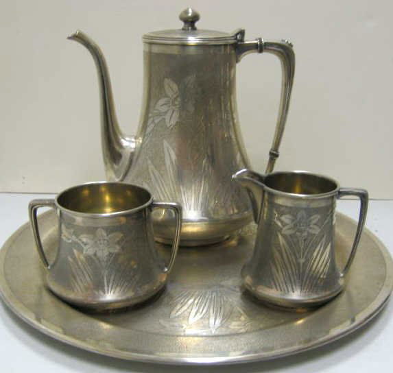 MULHOLLAND BROS. INC., AURORA, IL: Art Deco plated silver three-piece coffee set: pot (7 3/4), sugar bowl and creamer together with matching round tray (d. 12"), floral design on matted ground, circa 1915-1922.