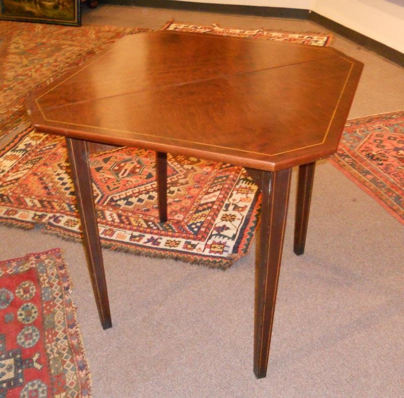UNIQUE SHERATON STYLE FOLDING GAMES TABLE: Square top with canted corners and line inlay crossbanding, folding flat in two triangular parts above the four tapering square legs, two with gate leg mechanisms, 20th century. Height 29 and 28 in. s