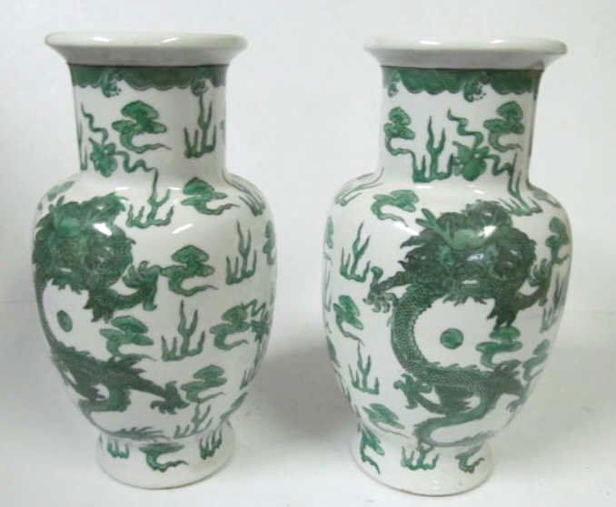 PAIR OF CHINESE GREEN AND WHITE CERAMIC VASES: Ovoid form with straight neck and flared rim. White glazed ground with hand-painted green dragons, waves, flames, and clouds. Height: 12 inches