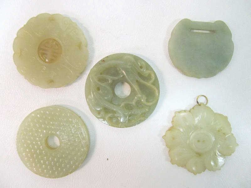 COLLECTION OF FIVE MINERAL STONE MEDALLIONS: Bi disk with grain pattern, disk with floral motifs, disk with wave motifs, disk with etched characters and disk with pierced medallion with moving characters. Diameters vary from 2 -2 1/4 inches