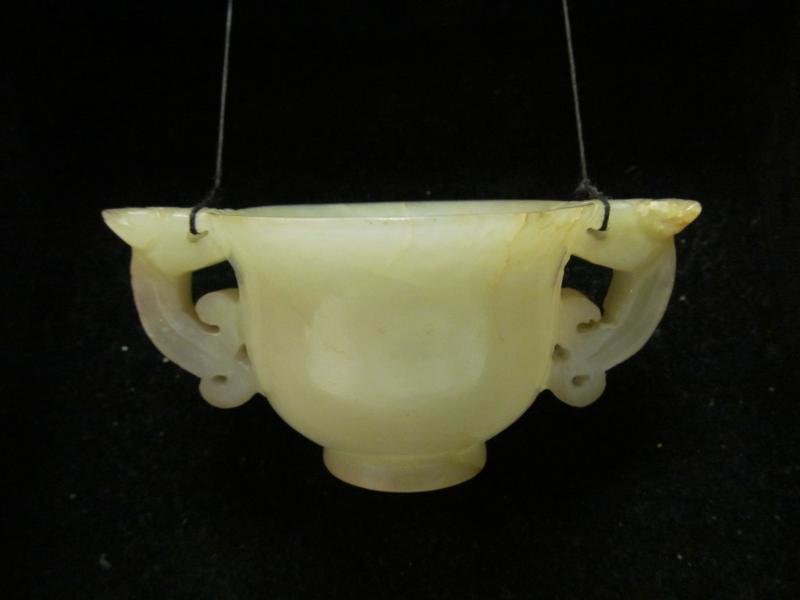 CHINESE JADE TWO-HANDLED CUP: Jade hand-carved cup with two dragon formed handles. Presented in shadow box display. Dimensions: 1 1/2 inches x 3 1/4 inches