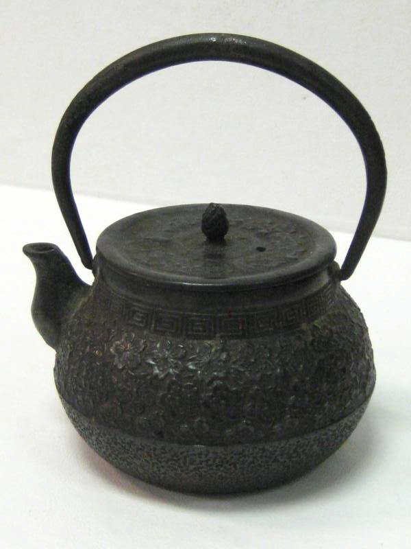 JAPANESE TETSUBIN CAST IRON TEAPOT: Iron Tetsubin Tea Ceremony teapot with floral and key motifs. Height 5 inches including handle.