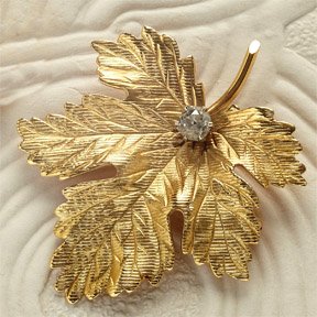 DIAMOND BROOCH: 14k yellow gold hand engraved oak leaf set with one old mine cut diamond weighing .33ct. 1 1/16 inches x 1 1/2 inches. 6.6 grams.