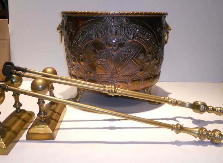 FIVE ENGLISH FIREPLACE ACCESSORIES: Copper repousse decorated log bucket showing coat of arms with applied brass lion-form handles and animal feet, 13 inches high, 16 inch diameter; pair of brass tool rest, brass ash tongs, 29 1/2 inche