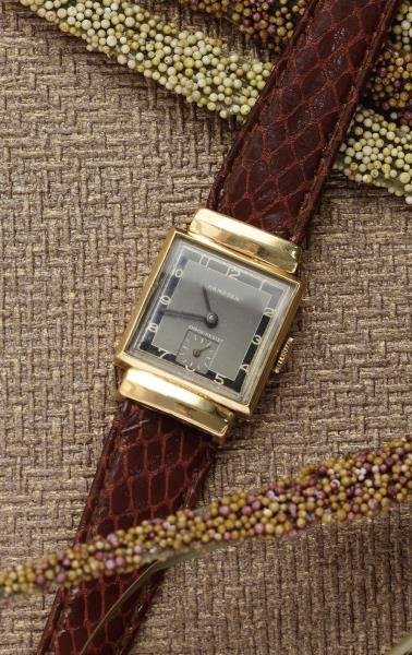 GOLD WATCH, HAMPDON: 14k yellow gold watch with a square grey dial with black trim and inset square second hand dial. Case is square with polished fluted lugs. Watch has a brown leather strap.