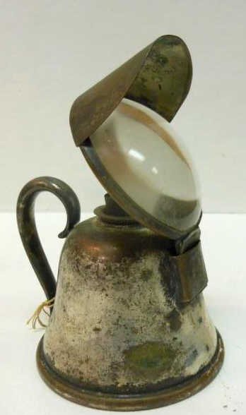 ENGLISH SILVER PLATE MAGNIFYING LENS OIL LAMP: A removable glass lens, fitted with a brass and tin double-tube whale oil burner, marked "LONDON", early 20th century, h. 5 1/4", dia. 3 3/8".
