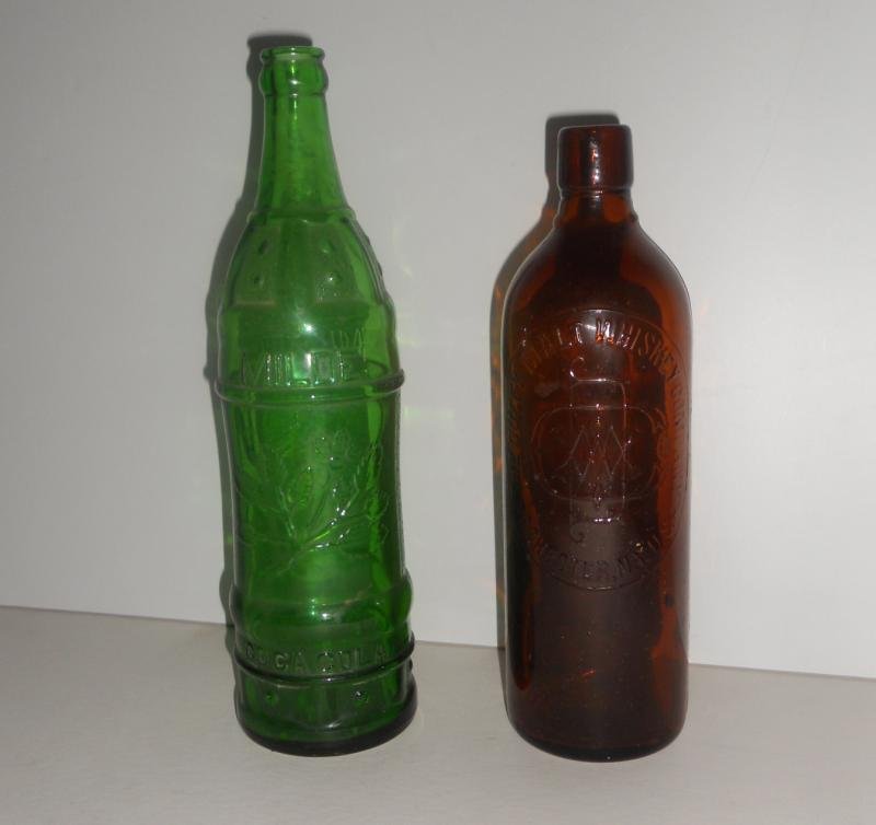 TWO VINTAGE AMERICAN BOTTLES: A green 11 1/2" tall 24 oz, Milde Coca Cola bottle, Flat River Missouri together with a brown 10 1/2" tall Duffy Malt Whiskey Co. bottle, Rochester, NY, patented 1886