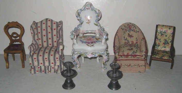 COLLECTION OF DOLLHOUSE AND MINIATURE CHAIRS: Meissen style porcelain armchair, upholstered wing chair, tub chair, side chair, armchair with open arms; together with a pair of pewter prick candlesticks, total 7 pieces.
