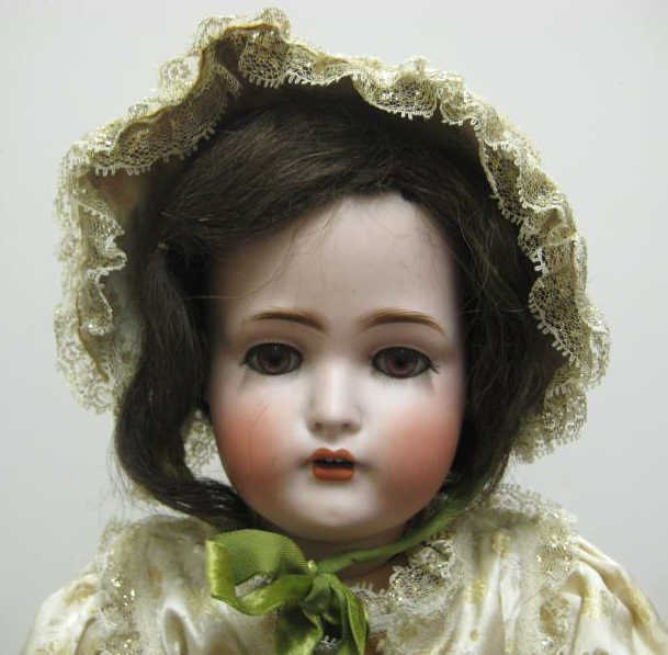 26" BRUNO SCHMIDT, GERMAN, BISQUE HEAD DOLL: Jointed composition body, wearing yellow satin dress and overcoat, circa 1900-1930.