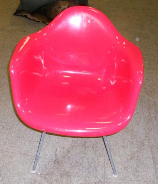 CHARLES EAMES FOR HERMAN MILLER: A vintage DAX chair with white medallion label, red enamel paint over original grey molded fiberglass, bears Herman Miller circular label on base. Height 31, width 23 3/4 in.