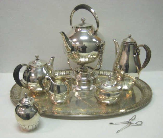 GEORG JENSEN, DENMARK: Six-piece pieces sterling silver tea/coffee service with matching oval tray, COSMOS pattern (#45) designed by Johan Rohde circa 1915, comprising a kettle on warming stand with light (13 5/8"), teapot