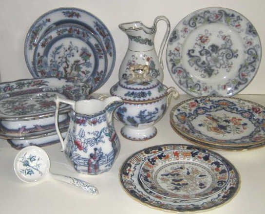 COLLECTION OF ENGLISH EARTHENWARE: Flow blue and polychrome enamel decorated in Imari style serving pieces by various makers including Copeland, Minton, T. Dimmock and Mason's comprising two jugs, two-handled pedestal trays, lidded sau