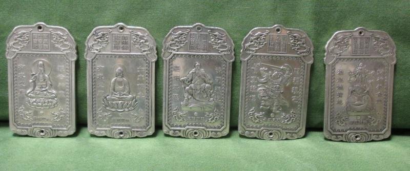FIVE CHINESE SILVER PLAQUES: Relief Buddhist decoration with inscriptions, pierced for cord. 2 1/4 x 3 3/4 in.; weight 21 troy ounces