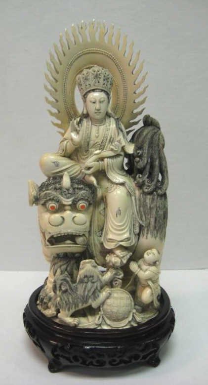 CHINESE IVORY FIGURAL GROUP OF MANJUSRI: Bodhisattva of Wisdom having flame-edge nimbus seated upon large fu lion holding ruyi scepter with pup and a figure of a Sudhana, apocryphal four character mark underfoot. Height 12 in. PROVENANCE Thi