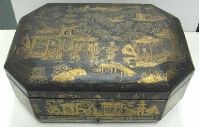 CHINESE EXPORT LACQUER SEWING BOX: Octagonal form with gilt scenes of oriental life, the hinged lid with inside mirror opening to reveal lift-out compartment tray, including two lidded and ivory sewing tools (some broken), a drawer on 
