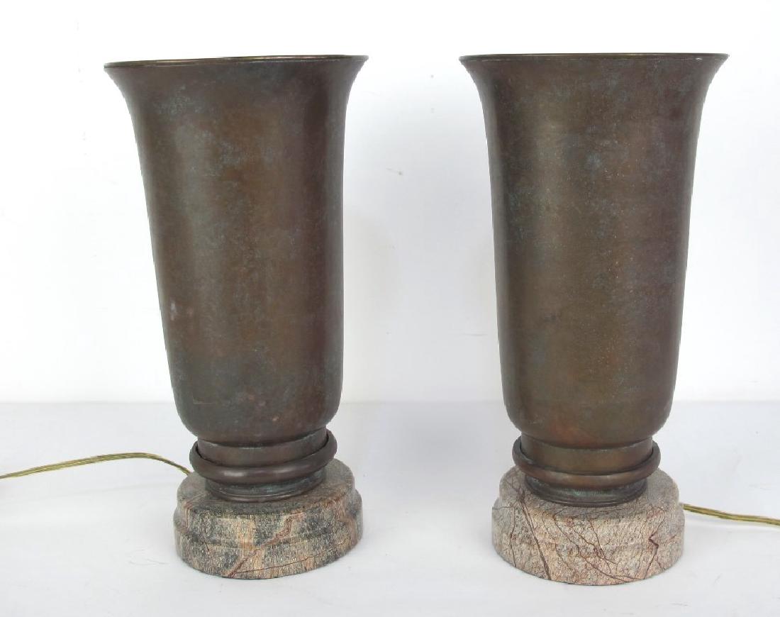 Pair of Bronze and Stone Lamps: Two bronze urn form lamps wired for electricity. Having cut brown stone bases. 13 inches height, 7 inches width, 7 inches depth. 13"H x 7"W x 7"D Measurements: 13"H x 7"W x 7"D Notes: Please carefully