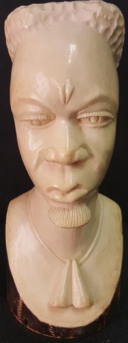 Carved Ivory Bust Figure: Carved ivory bust of a male figure with necklace and beard. African style. Crack to bottom. Open area with cap to top. 6 inches height, 2.5 inches width, 3 inches depth. 6"H x 2.5"W x 3"D Crack to bot