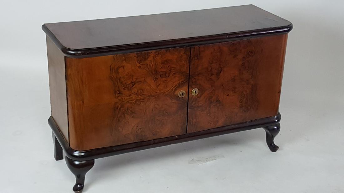 Burlwood Cabinet: Two-door burlwood cabinet having brass hardware. Curved form and pad feet. Light wear to finish. 29.5 inches height, 48 inches width, 17 inches depth. 29.5"H x 48"W x 17"D Light wear from age and use