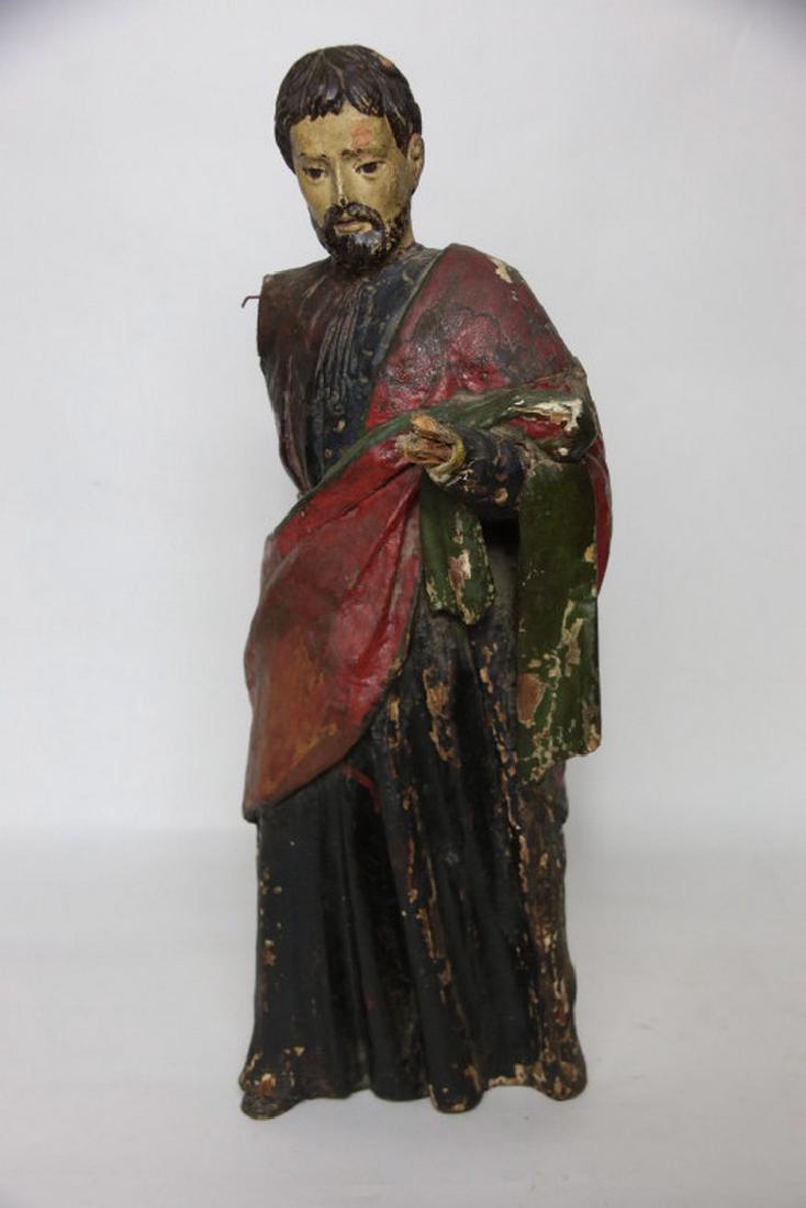 18th Century Carved Santos: Carved, hand painted wood sculpture of a male figure in robes. Heavy losses and wear from age and use. 23.5 inches height, 9.5 inches width, 6 inches depth. 23.5"H x 9.5"W x 6"D Heavy wear from age an