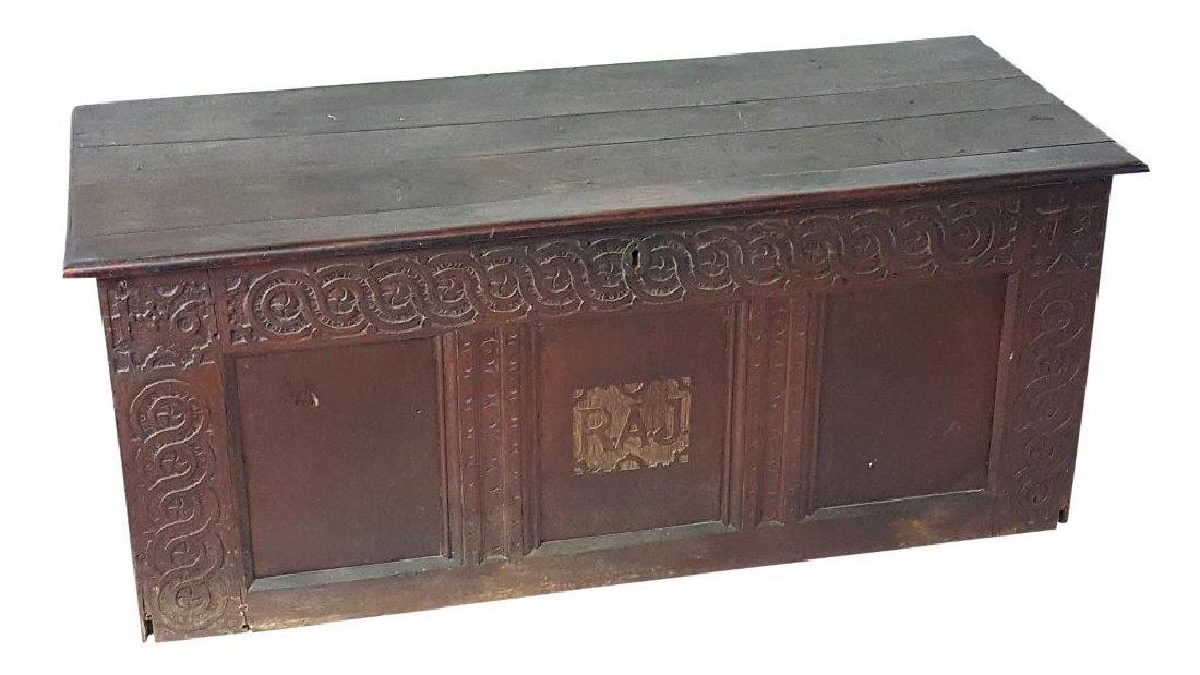 Carved Antique Chest: Hinged lid blanket chest made of dark wood. Carved serpentine motif to front with RAJ monogram. 20.5 inches height, 51.5 inches width, 21.5 inches depth. 20.5"H x 51.5"W x 21.5"D Wear from age and use