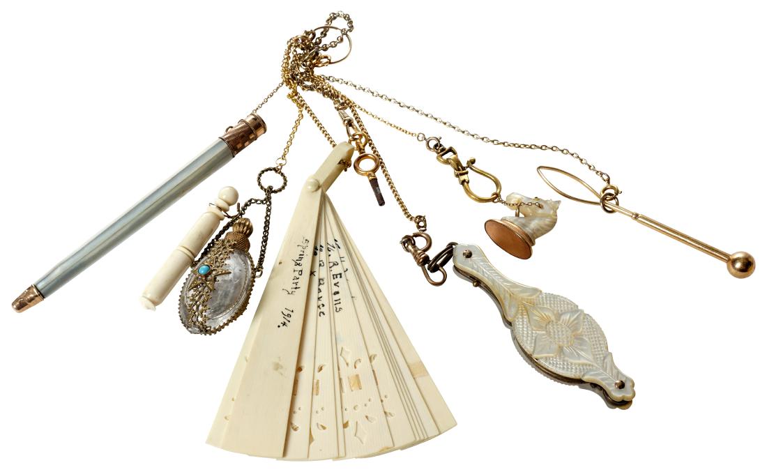 Gold Metal Chain With Six Implements: Various sizes makes and materials including bone fan, mother of pearl writing implement, mother of pearl horse form seal, perfume flask, drink stir, and lorgnette. This lot is located at 1502 N Lime A