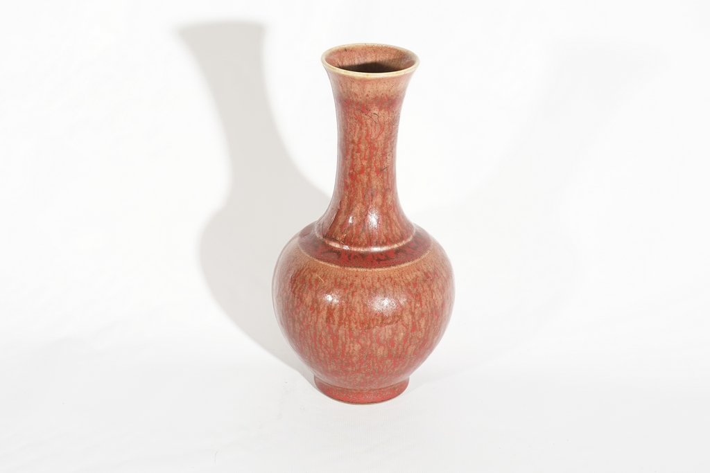Chinese Red Porcelain Vase: 20th c in a peachblow like glaze of sangre de boeuf and brown. Writing to underside. Good condition 10.5"H x 5.5"D