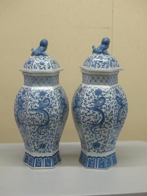 PAIR OF BLUE AND WHITE CHINESE VASES:: urn form with lids topped with blue fu dogs. Chinese character mark on underside. each 23"H