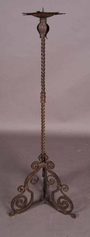 17TH C. ITALIAN WROUGHT IRON TORCHIERE:: with a spiral stem and a scrolled base.