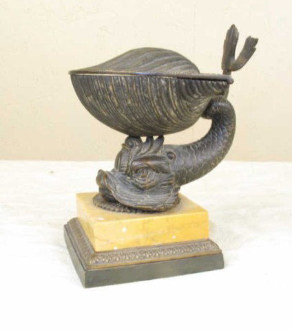 TIFFANY & CO. BRONZE INKWELL:: In the Italian manner. A bronze dolphin supporting a shell-form inkwell with hinged lid. Mounted on a yellow marble and bronze base. Stamped mark on one side of the base. 6.25"H, base 3.5" sq. From a 