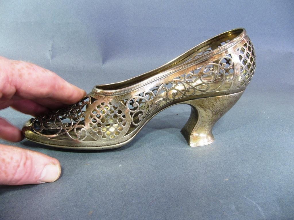 STERLING SILVER SLIPPER:: Having scrolling pierced decoration. Approximately 4"H X 12"L. Bearing maker's mark. Weighing approximately 9 toz. Marked sterling silver A5372. From a fine 68th Street Manhattan apartment.