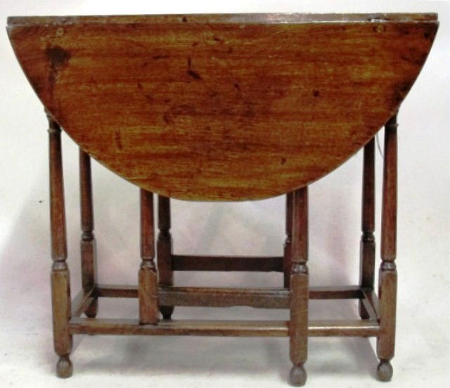 DIMINUTIVE ANTIQUE DROP LEAF TABLE: A gate leg oak table, having 8 turned legs. Fitted with a single drawer at the apron. 19th century. Good condition with typical wear. 35.5"L X 30.5"D X 26.5H" open dimensions Provenance: The Ferst est