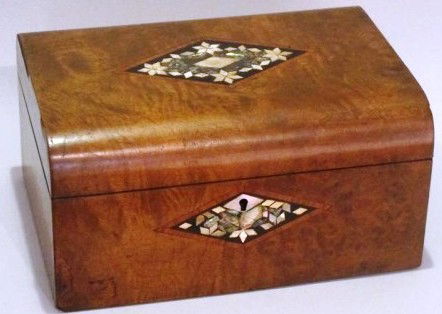 MOTHER OF PEARL INLAID BURLWOOD BOX: The top with a convex front and back, and centered with a diamond form mother or pearl and ebony inlay. This motif is repeated in the key escutcheon. 5.5"H X 8"D X 10.5"W Provenance: From a fine Buckh