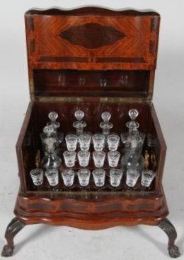 VERY FINE FRENCH MARQUETRY LIQUOR BOX: A tulipwood, rosewood, and mahogany cellarette fitted with 16 Baccarat liquor glasses and 6 decanters. On carved claw and ball feet. Circa 1820. 17"H X 16"D X 23"W