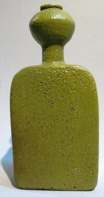 BEATRICE WOOD (AMERICAN, 1893-1998): Mid century. Abstract figural bottle in a pitted green glaze earthenware. Signed on underside "Beato". Note: Traces of green felt adhered to bottom. 9.25"H