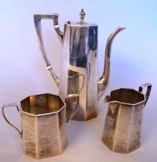 BLACK, STARR & GORHAM STERLING DEMITASSE SET:: A three piece,eight sided, art deco style demitasse set comprised of a handled coffee pot with hinged finial lid, a two handled sugar bowl and matching creamer. Ivory insulators on pot handle. Each pi