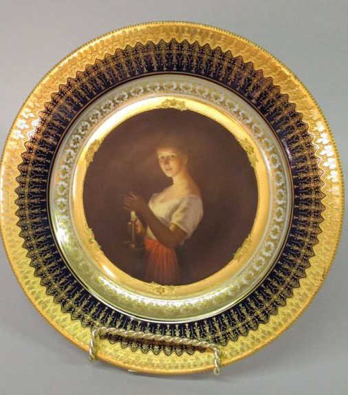 ROYAL VIENNA PLATE:: Having a cobalt rim with gilt decoration, and a center depicting a girl holding a candle. Bearing the Royal Vienna mark to verso and titled "Gute Nacht". 9.5"diameter Provenance: A fine Cumming, Georg