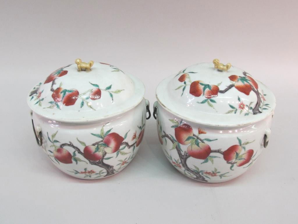 PAIR CHINESE LIDDED CACHE POTS: Painted in a fruiting branch motif, and having metal ring handles and dog figural finials to lids. Marked on undersides. 8"H X 9"W Note: Loss to one handle Provenance: The Ferst estate