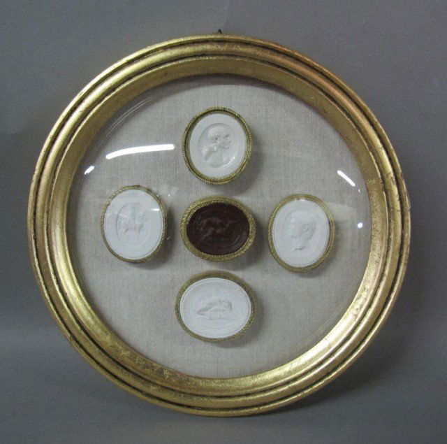 COLLECTION 5 FRAMED INTAGLIOS:: 19th/20th century. Four white intaglios surrounding a red intaglio, each gilt framed. All mounted and framed in a custom gilt shadow box. 7" diameter.