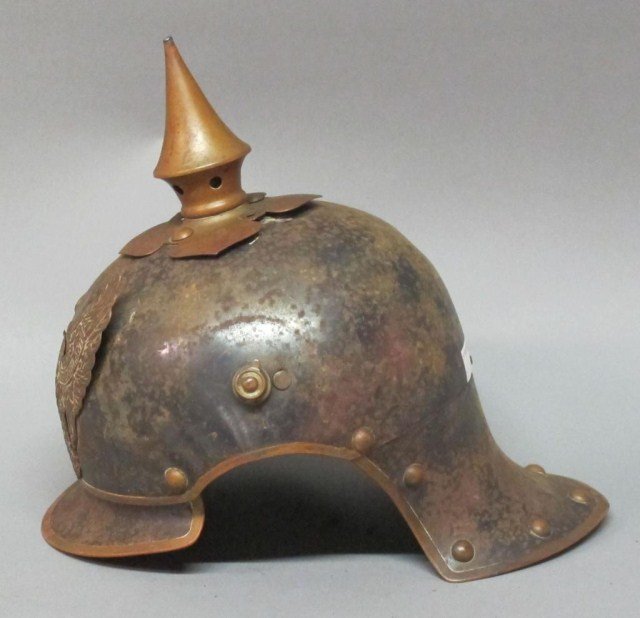 GERMAN WWI HELMET:: German Pickelhaube helmet. With brass eagle bearing the German inscription ""Mit Gott Fur Koening und Vaterland." (With God for King and Fatherland.) The brass mounted eagle and spike are loose. Exten