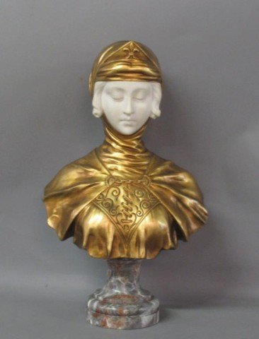 MARBLE & DORE JOAN OF ARC BUST:: Art Nouveau bust of Joan of Arc. The hair and face with serene expression carved in marble. The bust and head covering in gilt bronze. Mounted on a grey marble circular footed base. 18.5"H X 10.5"W