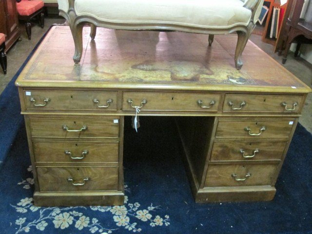 LEATHER TOP KNEE HOLE PARTNERS DESK:: A continental walnut partners desk with embossed leather top. Note: Extensive damage to leather surface. 30"H X 56"D X 39"W