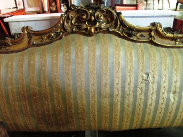 CARVED GILT & UPHOLSTERED HEADBOARD:: A green striped upholstered headboard with carved and gilt foliate crest. Note: Tear to upholstery. 49"H X 81"W