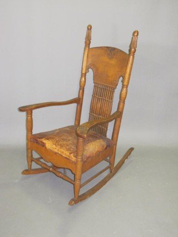 ANTIQUE ROCKING CHAIR:: A carved rocking chair with a brass studded embossed leather seat. Note: Damage to seat.