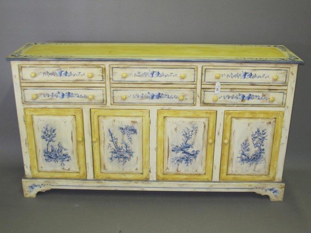 PAINT DECORATED SIDEBOARD:: A sideboard fitted with three drawers over four cabinet doors, painted in yellow and blue, with pastoral genre scene decorated cabinet doors and blue ivy trim at the surface. 38"H X 16.5"D X 68"W