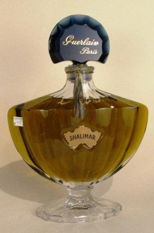 GUERLAIN "SHALIMAR" SIGNED PERFUME FLACON: Hand signed "Philippe Guerlain". A glass shell form flacon on pedestal with blue glass shell form stopper, containing "Shalimar" perfume. 15"H X 10"W