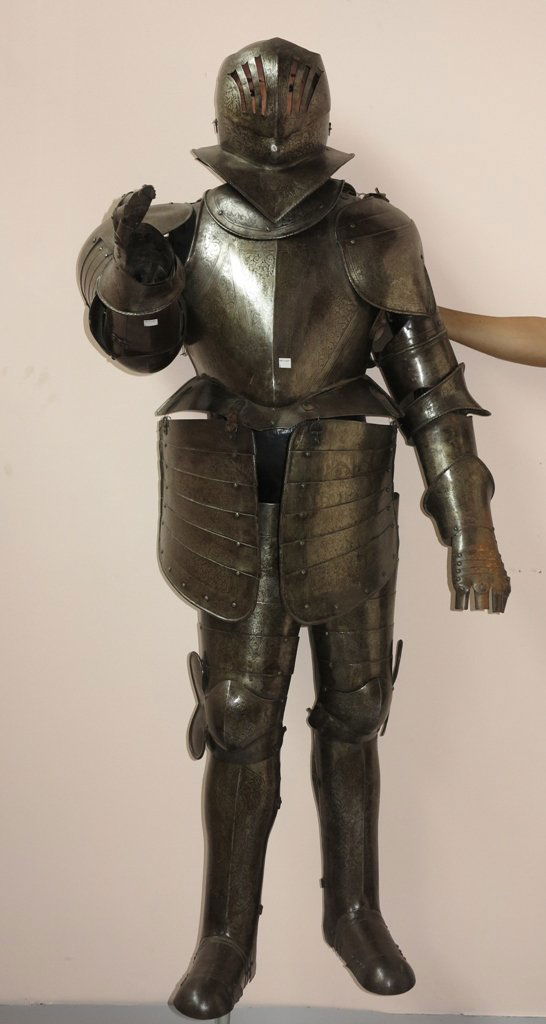 ANTIQUE CONTINENTAL SUIT OF ARMOR: An Antique Continental metal suit of armor with matching helmet having all over chased scrolled leaf decoration. Complete with boots, gloves, chest plate, and waist skirt. 66"H