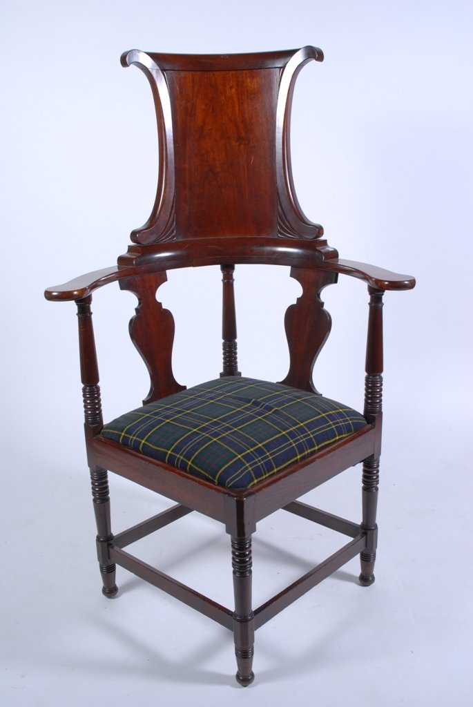 GEORGIAN STYLE CORNER CHAIR: An unusual Centennial Georgian style mahogany high back corner chair. The curved head rest above to vasi-form splats over a green plaid upholstered slip seat raised on spool turned legs having a full