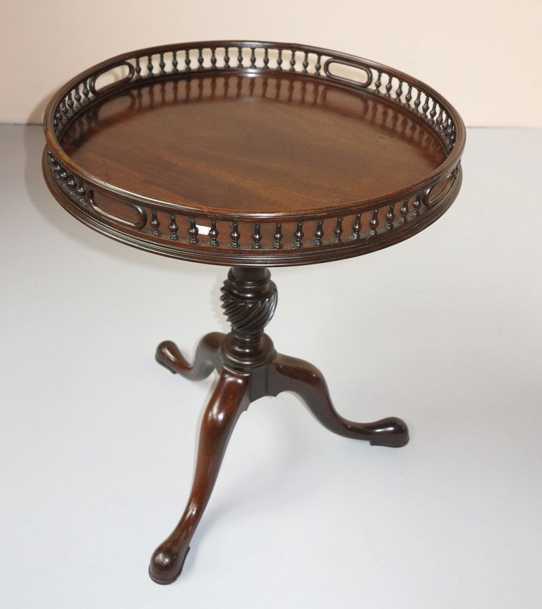 ENGLISH GEORGIAN STYLE TEA TABLE: A fine antique mahogany tea table. The Circular top, having a balustrade gallery fitted with four oval pierced handles, raised on a turn-twist baluster form standard resting on tripod curved legs term