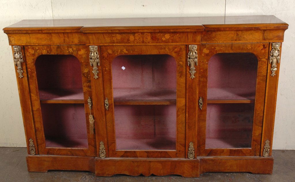 VICTORIAN MARQUETRY INLAID CREDENZA: A breakfront credenza with three glass door cabinets, having gilt bronze figural mounts and floral marquetry inlay. Note: Glass broken at left cabinet. 41.5"H X 14"D X 70"W